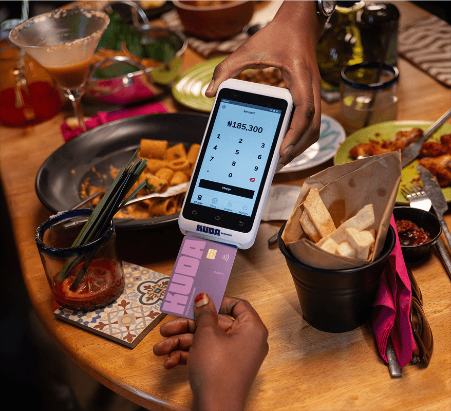 A customer paying with a Kuda card at a POS terminal over a table of food